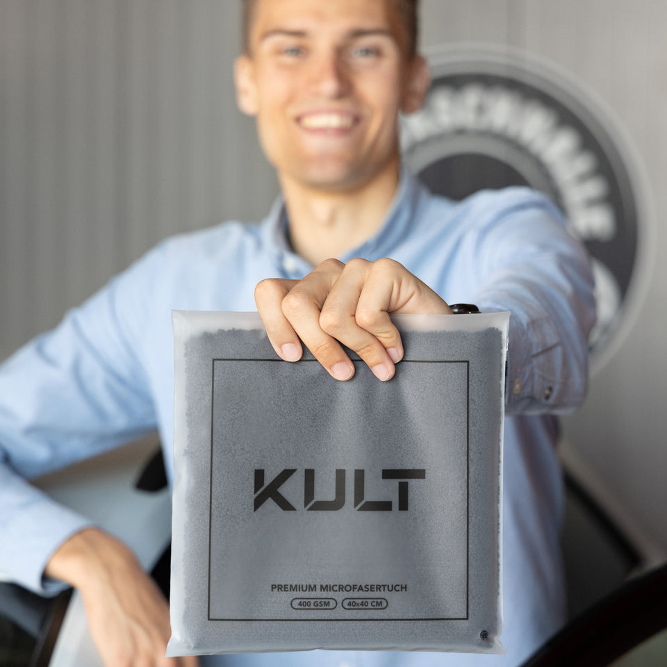Gründer Nikolai Kulterer zeigt das KULT Premium Microfasertuch in der Verpackung