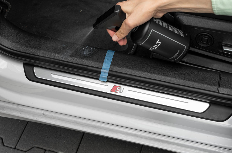 KULT Innenraumreiniger wird auf eine Einstiegsleiste gesprüht