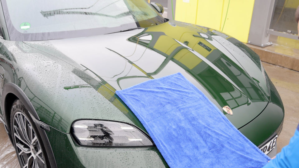 Blaues KULT Premium Auto Trockentuch liegt auf der nassen Motorhaube eines dunkelgrünen Porsche Taycan
