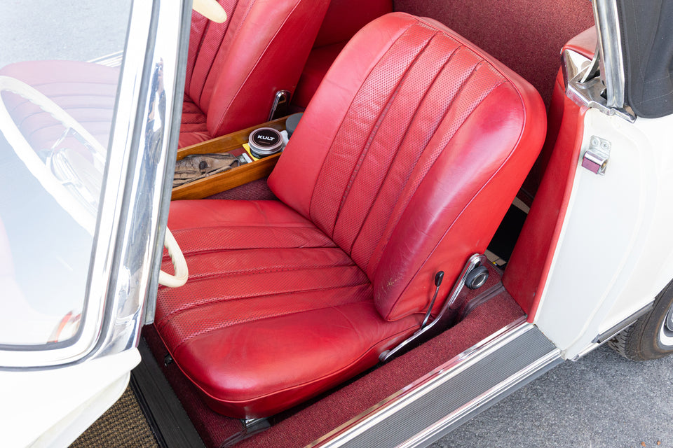 Roter Originalledersitz eines Mercedes 230 SL Pagode, auf der Mittelkonsole steht die Dose der KULT Lederpflege