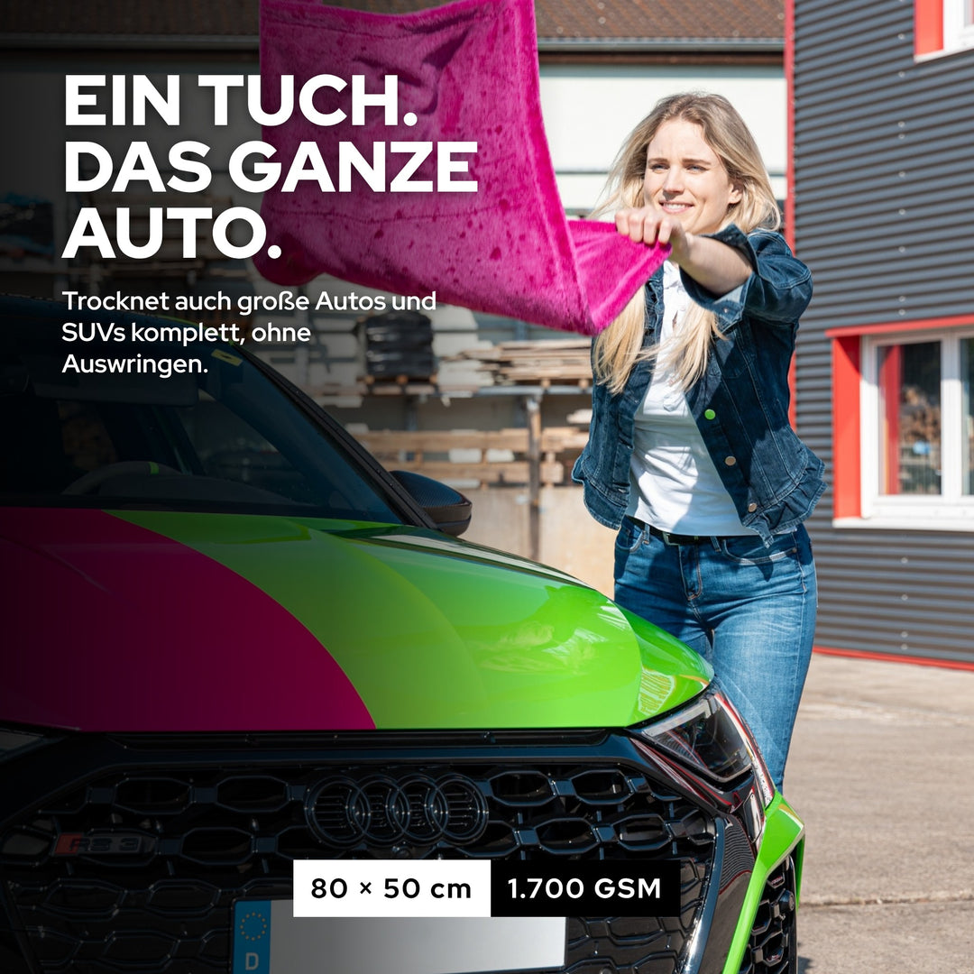 Frau trocknet ein Auto mit dem pinken KULT Premium Auto Trockentuch, ein Tuch für das ganze Auto