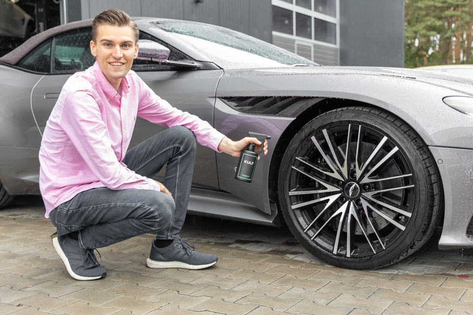 Gründer Nikolai Kulterer mit dem KULT Felgenreiniger an der Felge eines Aston Martin DBS