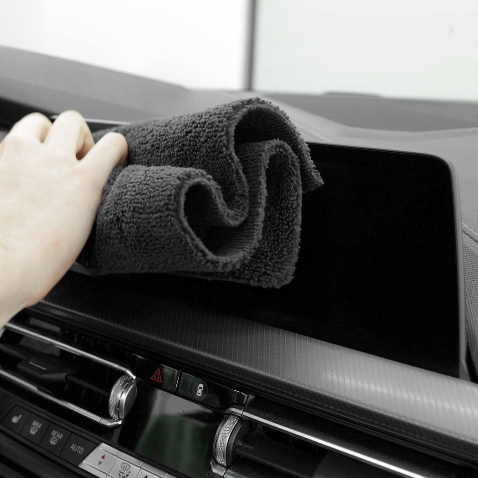Touchscreen im Auto wird mit einem Mikrofasertuch gereinigt