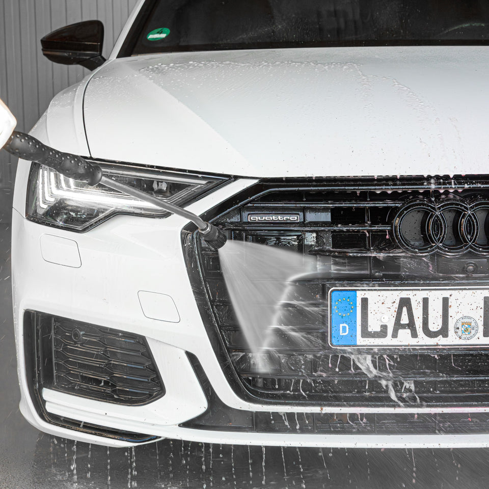 Front eines weißen Audi A6 wird nach dem Insektenentferner mit Hochdruck abgespült
