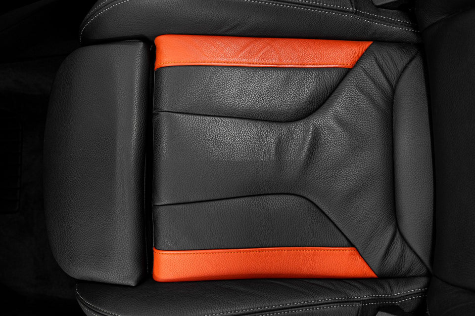 Ledersitz eines BMW 235i aus schwarzem Leder mit orangefarbenen Lederbahnen