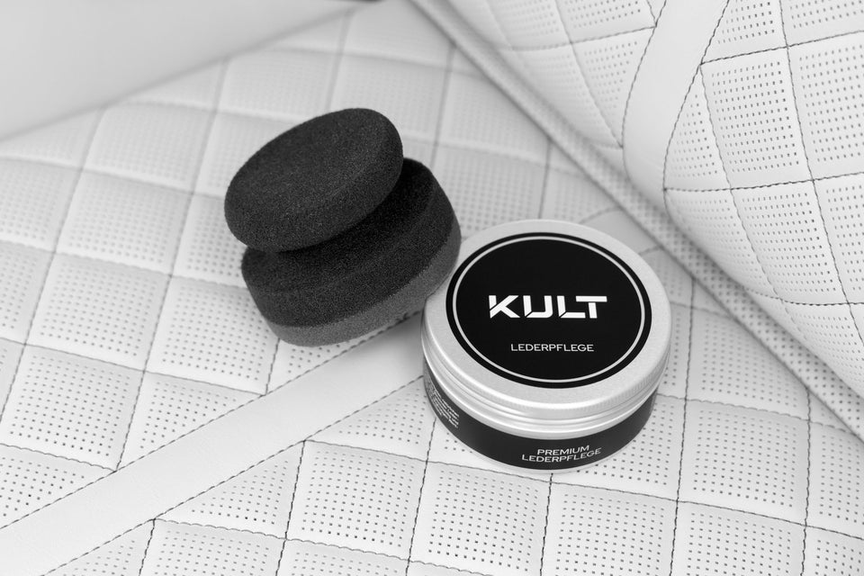 KULT Pflege Applikator und Dose der KULT Lederpflege auf hellem, perforiertem Leder